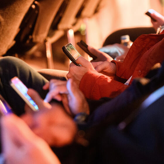 A row of people looking at smartphones