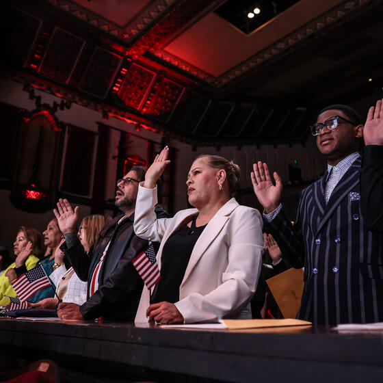 New citizens raising their right hands at a ceremony