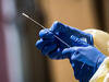 A healthcare worker holding a COVID-19 testing swab