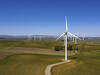 A wind farm in Rio Vista, California, with a path winding toward the turbine in the foreground