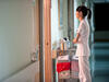 A nurse standing outside a hospital room