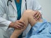 A closeup of a doctor examining a knee