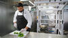 A Chipotle chef with Chippy, an autonomous kitchen assistant that makes tortilla chips