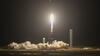 A rocket takes off from a launch pad at night