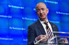 Jeff Bezos in front of a screen with the Washington Post logo