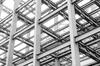 A black and white photo of steel beams in a building under construction